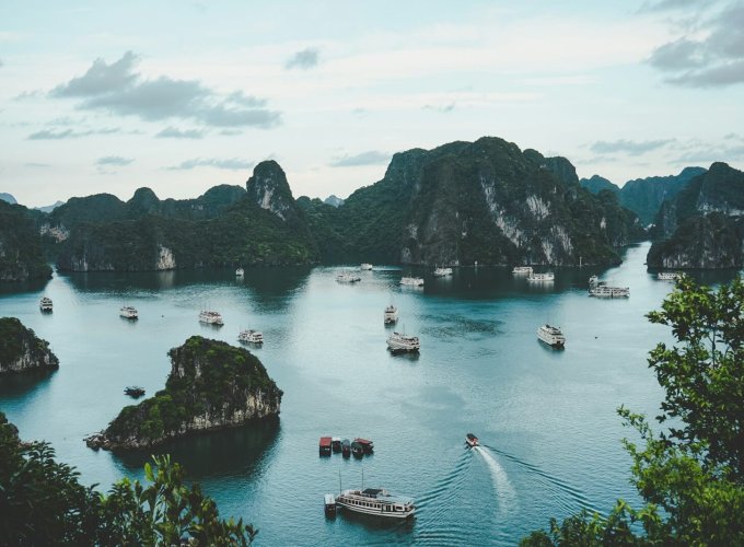 high-angle photography of boats on water near hill during daytime
